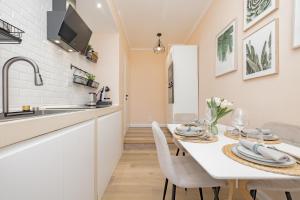 a kitchen and dining room with a white table and chairs at Visconti Apartment by Rhospitality it in Rho