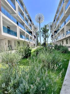 an apartment building with a garden in front of it at EM House in Otopeni
