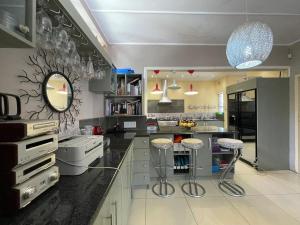 a kitchen with a counter and stools in it at 3-Bedroom Oasis with Pool in Johannesburg