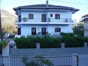 una casa blanca con una valla delante en Garden Villa en Ioánina