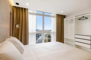 a bedroom with a white bed with a large window at Luxury Loft Mar y Sol 2 in Tacoronte