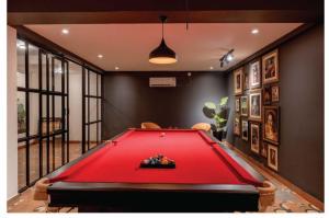 una sala de billar con una mesa de billar rojo en AmagoVillas, en Marna