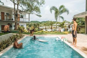 SalinasWaves & Wifi - Coworking & Coliving Space in Popoyo的一群人在游泳池里,那里有冲浪板