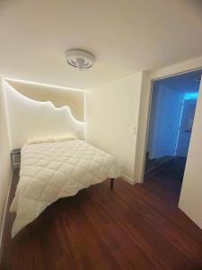 a bedroom with a bed in a room with wood floors at Paris maison-4min à Métro7-18min au centre de Paris in Villejuif