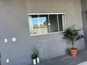 a room with a window and two potted plants at Residencial Jasmim quarto Standard 01 in Palmas