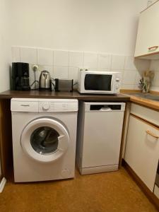 a kitchen with a washing machine and a microwave at Park und Therme in Bad Wildbad +3 photos