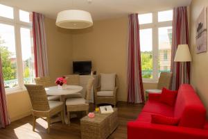 a living room with a red couch and a table at Résidence de Tourisme Vacances Bleues Villa Regina in Arcachon