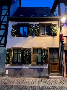 a house with plants on the windows and a door at Le Trente à Turckheim in Turckheim