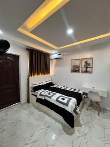 Cozy Studio Apartment, 24hrs light, Netflix, PS in Surulere, Lagos في لاغوس: غرفة نوم بسريرين ومكتب فيها +صورة واحدة