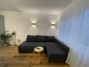 a living room with a black couch and a window at zentrales Appartement zwischen Messe und Altstadt in Düsseldorf