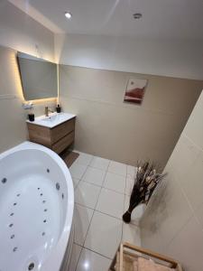 a bathroom with a tub and a sink and a toilet at Appartement Près de Paris, Disney & CDG in Tremblay En France