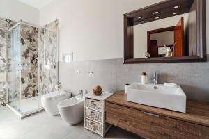 une salle de bain avec un lavabo, des toilettes et un miroir dans l'établissement Casa Vacanze Solemare Sciacca, à Sciacca 46 autres photos
