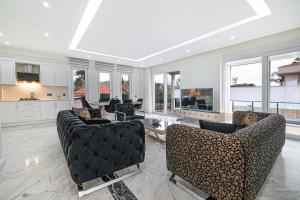 a living room with couches and a kitchen with windows at Kemer Vıllas De LLuvia in Kemer