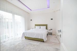 a white bedroom with a bed and a window at Kemer Vıllas De LLuvia in Kemer +43 photos