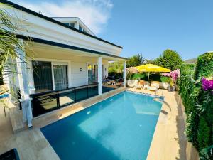 a swimming pool in front of a house at Kemer Vıllas De LLuvia in Kemer