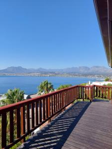 a wooden deck with a view of the ocean at Bay View Cabin in Gordonʼs Bay