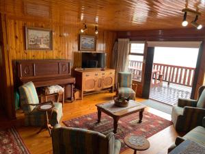 a living room with a couch and a table and a television at Bay View Cabin in Gordonʼs Bay