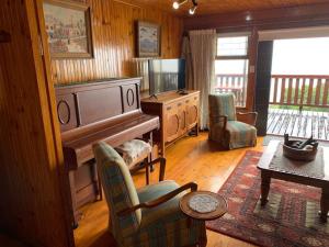 a living room with a piano and a table at Bay View Cabin in Gordonʼs Bay