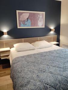 a bedroom with a large bed and a painting on the wall at Maison Avignon Intramuros Clim Wifi 2 chambres Idéal Festival in Avignon