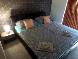 a bedroom with a bed with a blue comforter and pillows at Súkromný apartmán in Senec