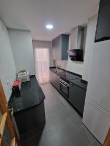 een kleine keuken met zwarte aanrechtbladen en apparatuur bij Marfil 6 in Salobreña