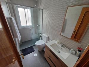 een badkamer met een toilet, een wastafel en een spiegel bij Marfil 6 in Salobreña +18 foto's