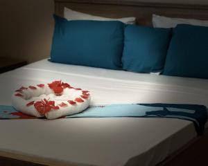 a bed with blue pillows and a toy on it at LESSENCIEL in Dzaoudzi