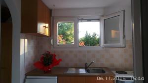 a kitchen with two windows and a sink at Skiathos Studios Panorama in Skiathos
