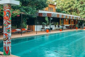 a swimming pool in front of a hotel at Hôtel Ricardo in Ouagadougou