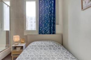 a bedroom with a bed with a blue curtain and a window at L'idéal à 2 pas de Paris et du métro dhhimmo in Vanves