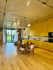 a kitchen and dining room with a table and chairs at Villa Ambassadori Kachreti Golf Resort in Gurjaani
