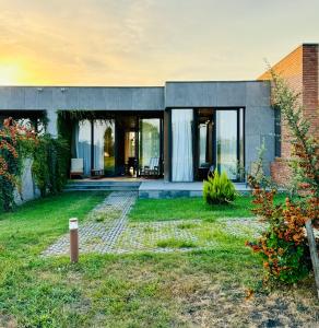 a house with glass doors and a yard at Villa Ambassadori Kachreti Golf Resort in Gurjaani +19 photos