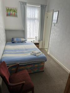 a bedroom with a bed and a chair and a window at The Stage Door Hotel in Blackpool