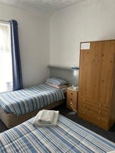 a hotel room with two beds and a dresser at The Stage Door Hotel in Blackpool +12 photos