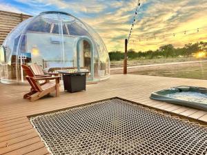 a gazebo on a deck with a hot tub and a igloo at Draco at the Retreat in Fredericksburg