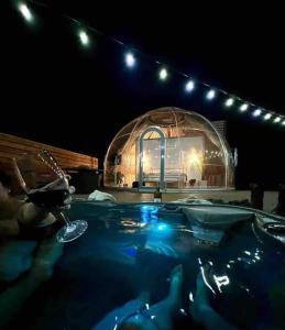a swimming pool with a glass house in the background at Draco at the Retreat in Fredericksburg