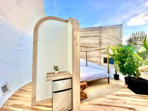 フレデリックスバーグにあるThe Bubble at the Retreatのベッド1台とテーブル付きのバルコニーが備わる客室です。