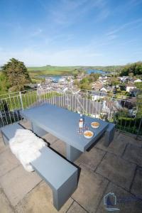 a blue table and bench on top of a balcony at Ultimate Coastal Escape - Stylish & Estuary Views in Salcombe