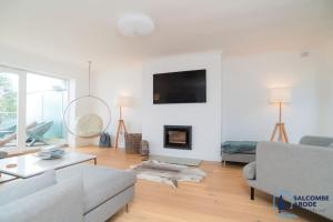 a living room with a couch and a fireplace at Ultimate Coastal Escape - Stylish & Estuary Views in Salcombe