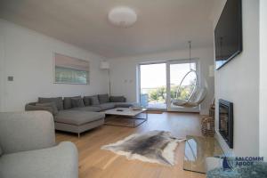 a living room with a couch and a table at Ultimate Coastal Escape - Stylish & Estuary Views in Salcombe