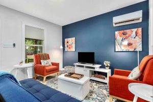 a living room with a couch and chairs and a tv at Guest Haus w Hot tub, Fire Pit & Vineyard Views in Fredericksburg