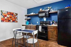 a kitchen with a table and a black refrigerator at Guest Haus w Hot tub, Fire Pit & Vineyard Views in Fredericksburg