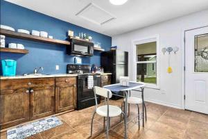 a kitchen with blue walls and a table and chairs at Guest Haus w Hot tub, Fire Pit & Vineyard Views in Fredericksburg
