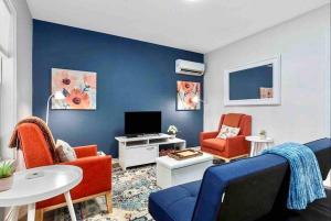 a living room with red chairs and a blue wall at Guest Haus w Hot tub, Fire Pit & Vineyard Views in Fredericksburg +24 photos