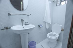 a white bathroom with a sink and a toilet at MERU MODERN LIVING BNB 1 AND 2 BEDROOMS in Meru +30 photos