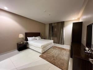 una habitación de hotel con una cama y un televisor en شقق واو جراند طريق الملك - منزل ابحر سابقا, en Yeda