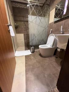 un baño con inodoro y lavabo en شقق واو جراند طريق الملك - منزل ابحر سابقا, en Yeda 28 fotos más