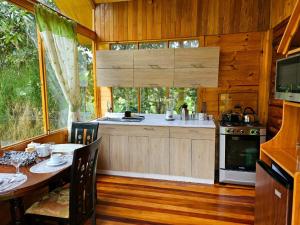 a kitchen with a table and a stove in a cabin at HASSINGER RANCH Cabañas in Oxapampa +45 photos