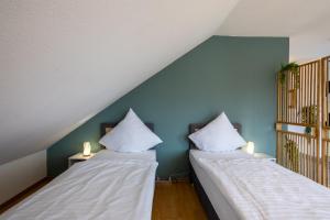 two beds sitting next to each other in a room at Helles Wohlfühl Apartment - Ruhig & Citynah in Reppenstedt