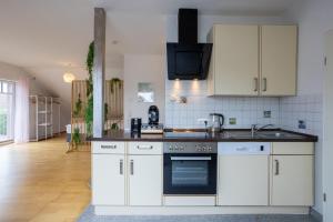 a kitchen with white cabinets and a stove top oven at Helles Wohlfühl Apartment - Ruhig & Citynah in Reppenstedt